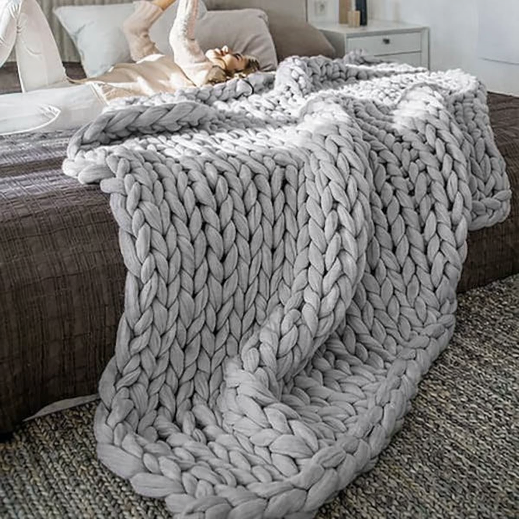 Elegant grey chunky knit throw draped over a bed for cozy layered styling