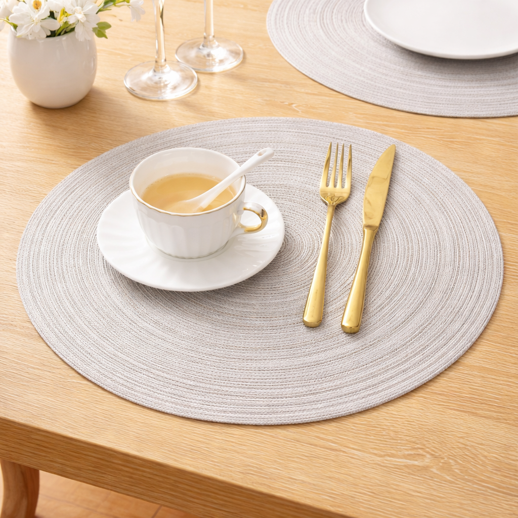 Premium light grey woven placemats styled on a modern wooden dining table