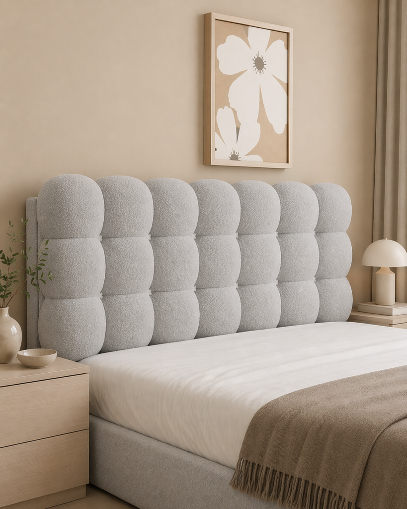 Light grey upholstered bolster cushion panel with soft rounded sections in a modern bedroom setting